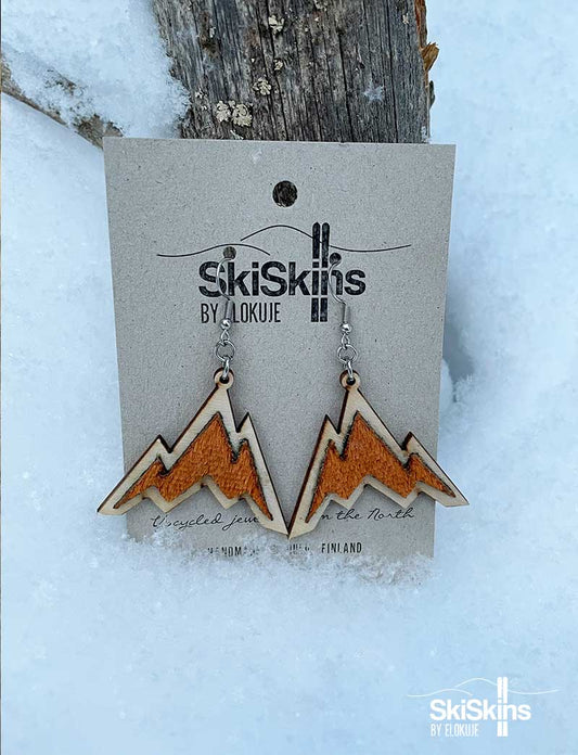 Käytetystä nousukarvasta tehdyt vuoren malliset oranssit korvakorut puutaustalla