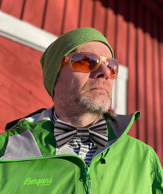 Harrin kaulassa Black Diamond -nousukarvasta käsin tehty musta-harmaa-raitainen rusetti